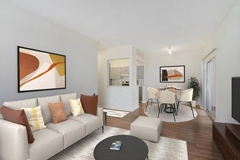 A living room with a grey sofa and a painting on the wall.